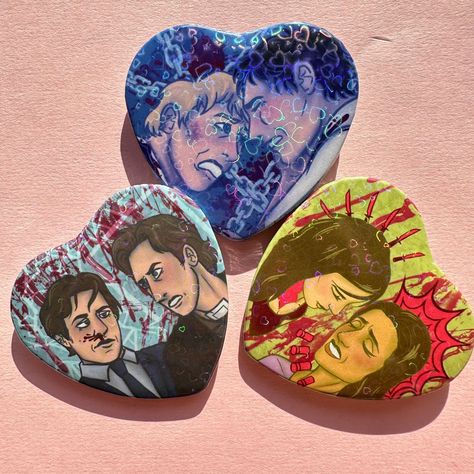 🧩 saw inspired heart holographic button badges featuring saw couples ⛓️ 2" heart pin 🪚 front of pin is holographic hearts*  🩸saw couples include lawrence gordon + adam stanheight (chainshipping), amanda young + lynn denlon (shotg*nshipping, lynnmanda), and mark hoffman + peter strahm (coffinshipping, hoffstrahm)   *holographic appears best in full sunlight Mark Hoffman X Peter Strahm, Adam X Lawrence Saw, Lawrence Gordon, Peter Strahm, Saw Drawing, Jigsaw Movie, Adam Stanheight, Mark Hoffman, Saw Series