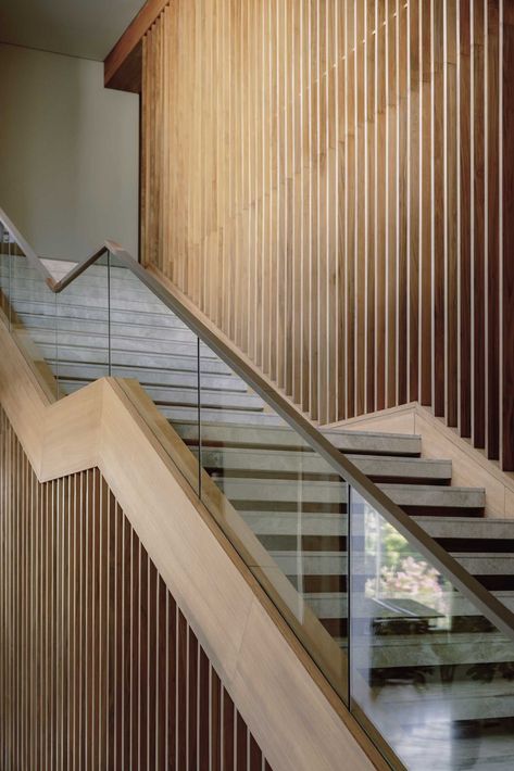 A modern home with a staircase that includes a glass and wood handrail. Glass Handrail, Staircase Handrail, Building Stairs, Timber Slats, Glass Stairs, Glass Staircase, Outdoor Dining Room, Staircase Railings, Wooden Staircases