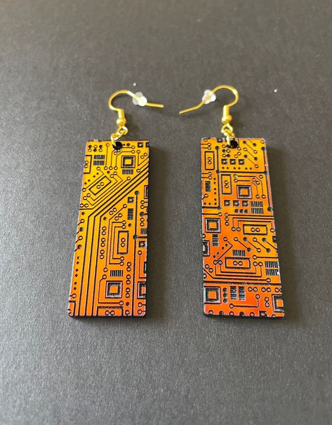 These stunning STEM inspired acrylic earrings are sure to be your favorite pair! An array of circuits decorate these rectangular shaped dangle earrings. The earrings are very lightweight and airy, so they are comfortable to wear all day! The perfect gift for your favorite engineer or STEM professional. Available in several colors - sunset iridescent that shifts from orange to green, or the subtle sparkle silver. Details: * Designed and created by Elishka Jepson * Available colors:    - Sunset ir Cyberpunk Accessories, Circuit Board Design, Tech Jewelry, Watercolor Bookmarks, Acrylic Jewelry, Funky Earrings, Recycled Jewelry, Clay Jewelry Diy, Acrylic Jewellery