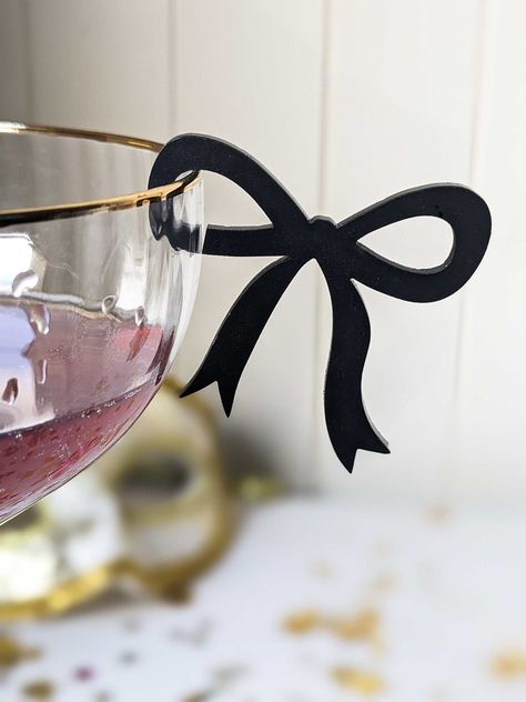 🥂  These stemless, clip-on drink bow tags are the talk of the party! Everyone is having the night of their lives, there's social media proof everywhere and these bow drink clips will create unforgettable memories that will linger long after the party ends. 🥂  🥂 Effortless setup - clip on easily and quickly to any glass 🥂 Reusable and Washable: Simply wipe clean for reuse 🥂 Glamorous Style: Perfect for any event-  hen's parties, bachelorette's, bridal showers, weddings, engagements, baby showers, tea parties, birthdays, happy hours, everyday drinking 🥂 Instant Transformation, turning any gathering into a social media-worthy affair. Leaving a lasting impression on guests and also serves as party or wedding favour! 🥂 Every coquette bow drink tag clip is 45mm x 50mm with a 2mm gap for t Drink Topper, Fest Temaer, Bridal Shower Balloons, Drink Tags, Birthday Goals, White Bridal Shower, Bachelorette Decorations, Lingerie Shower, Dinner Themes