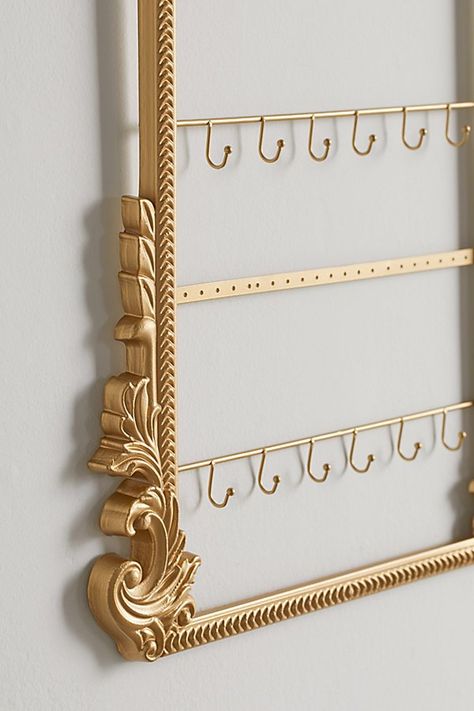 Turn your jewelry collection into a statement centerpiece with this jewelry organizer featuring four tiers made up of a mix of hooks for your necklaces and perforations for your earrings. Finished with intricate detailing around the frame. Features Statement jewelry holder Ornate sculpted frame crafted from wood Gold finishes for an antique feel 4 Tiers - hooks for necklaces & perforations for earrings! Content + Care Wood, iron Spot clean Imported Size Dimensions: 16" l x 0.7" w x 20" h Weight: Aesthetic Jewelry Organizer, Jewlerie Organizer, Bedroom Jewelry Organization, Jewelry Boutique Display, White And Gold Room Decor, Jewlwey Organizer Aesthetic, Aesthetic Jewelry Holder, Cute Jewelry Holder, Jewelry Organizer Aesthetic