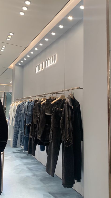 clothing rack with denim clothes in miu miu store Miu Miu Store Interior, Miu Miu Store Aesthetic, Clothing Store Aesthetic Interior, Luxury Store Aesthetic, Boutique Aesthetic Ideas, Dior Store Aesthetic, Fashion Store Design Boutiques, Aesthetic Clothing Store Interior, Harrods Aesthetic