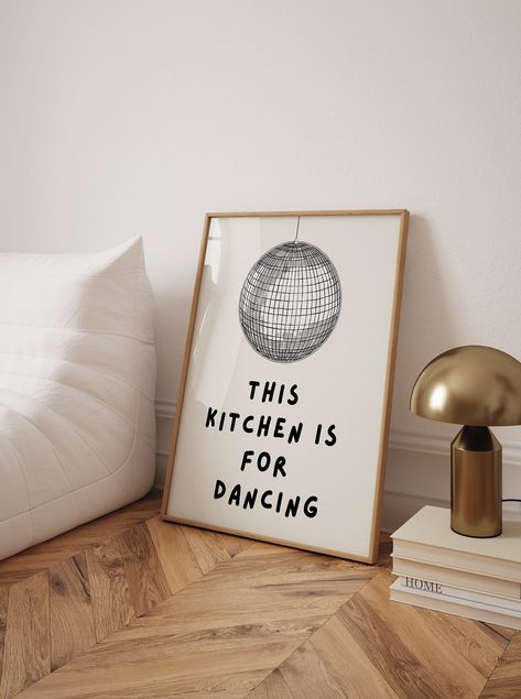 Add a playful touch to your kitchen decor with this trendy "Kitchen is for Dancing" poster. Featuring a whimsical disco ball illustration and the fun text "This kitchen is for dancing," this high-quality art print brings a lively and cheerful vibe to any cooking space. Perfect for those who love to dance while they cook, this poster serves as a joyful reminder to enjoy every moment in the kitchen. Its vibrant and engaging design makes it an excellent addition to your wall, creating an inviting and energetic atmosphere. This unique kitchen wall art also makes a fantastic gift for friends and family who share a love for food and dancing. Kitchen is for Dancing Poster, Trendy Kitchen Print, Cool Cute Cooking Kitchen Art Print, Kitchen Wall Poster, High Quality Print, Disco Ball Kitchen Poster Disco Ball Illustration, Cute Cooking, Kitchen Wall Prints, Fun Kitchen Decor, Ball Illustration, Kitchen Is For Dancing, Dancing In The Kitchen, Poster High Quality, Dance Poster