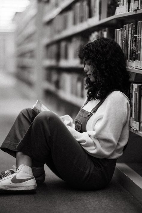 A black and white photograph of a woman sitting on the ground of a library reading a book. Cute Library Pictures, Photo Shoot In Library, Photography Poses In Library, Photography In Library, Photoshoot Moodboard Inspiration, Photoshoot In Bookstore, Photoshoot In A Library, Ny Public Library Photoshoot, Photoshoot Library Photo Ideas