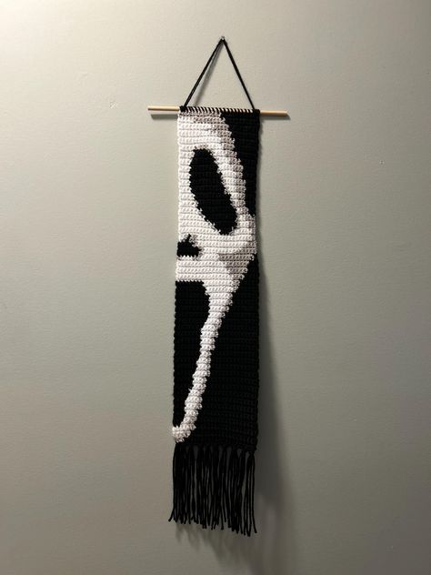 This is a finished item, not a pattern.  Halloween ghost crochet wall hanging.  Perfect for any Halloween movie lover.  The measurements are: -21in long not including the fringe  -26in long including fringe  -30.5in long from hook to fringe  -5.25in wide This wall hanging is made with acrylic yarn and has a wooden dowel rod. It is very lightweight and can hang from a nail, push pin, or anything you want to hang it from. Ghost Face Crochet Pattern, Diy Tapestry Wall Hanging, Halloween Crochet Tapestry, Ghost Face Crochet, Crochet Seasonal, Reaper Quotes, Crochet Halloween Decorations, Spooky Crochet, Ghost Crochet