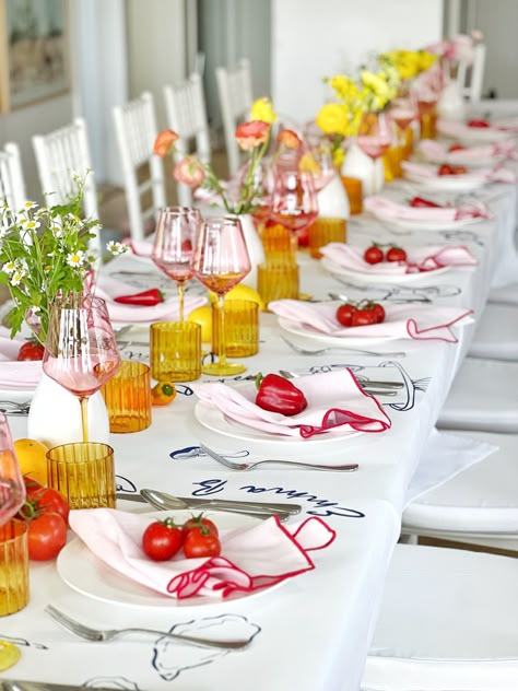 Mediterranean themed table with custom printed table decor, coloured glassware, pretty pink napkins, beautiful flowers and tomatos, lemons, oranges and capsicum as the finishing touch to add some bright colours. 🍅🫑🍋🍊 Bright Table Setting, Mediterranean Christmas Decor, Mediterranean Theme Party, Mediterranean Table Setting, Garden Dinner Table, Mediterranean Tablescape, Tuscan Tablescape, Bright Tablescape, Mediterranean Christmas