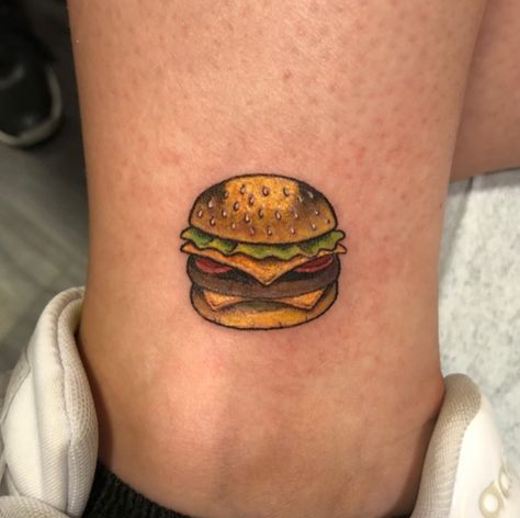 This is a fast-food tattoo of a burger. If you enjoy eating burgers, you should show your affection for them by getting a burger design tattooed on your body. This bright burger tattoo adds a realistic and feminine touch to... Burger Tattoo, Burger Design, Food Tattoos, Tattoo Color, Ankle Tattoo, S Tattoo, Couple Tattoos, Infinity Tattoo, Cheeseburger