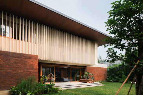 Located in the heart of South Jakarta, this house was designed as a response to the tropical climate. The building consists of 3 main masses, the front is the semi-public area which includes a garage, service area, powder room, and working room. The front part is a brick rectangular box with a compressed wooden ceiling, creating a transitional entrance to the main area. Every room is designed with a big opening to have good air circulation and natural light. Big Balcony, Mid Century Exterior, Studio 17, Floating Stairs, Patio Designs, Big Windows, Modern Tropical, Tropical Houses, Interior Design Companies