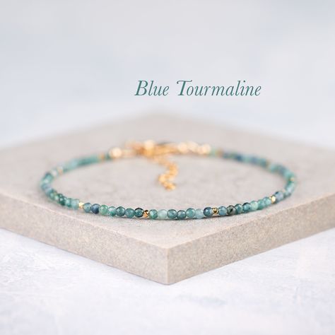 Unusual and beautiful tiny Blue Tourmaline gemstones are  faceted for maximum sparkle and accented with your choice of either Sterling Silver or Gold Vermeil beads in this very dainty and delicate little bracelet. - Completely natural genuine gemstones measure approx. 2mm - Bracelet extends from 6.5-8 inches (custom sizes available on request) - Comes packaged in a gift box with gemstone information card - Choose from Gold Fill or 925 Sterling Silver - Matching necklace: www.etsy.com/uk/listing/ Delicate Beaded Bracelets, Natural Gemstone Bracelets, Stretchy Bracelets Diy, Diy Jewelry Packaging, Sterling Silver Stacking Bracelets, Tiny Bead Bracelet, Sundance Jewelry, Information Card, Beaded Jewelry Designs