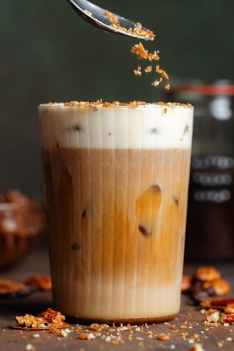 This Starbucks copycat Pecan Crunch Oat Milk Latte is the best fall and winter coffee drink! It's made with homemade butter pecan syrup and homemade pecan praline crunch. It's vegan, gluten-free, and so delicious! You'll love this for the holidays or anytime during the year! You can make the latte both hot and iced. Iced Coffee For A Crowd, Winter Coffee Syrup, Pecan Coffee Syrup, Starbucks Pecan Crunch Oat Milk Latte, Pecan Syrup For Coffee, Paleo Coffee Drinks, Starbucks Pecan Crunch Latte, Toffee Nut Starbucks Iced Coffee, Butter Pecan Coffee Syrup