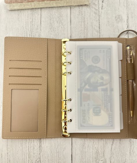 A6 Wallet comes with 5 frosted envelopes and is conveniently sized to fit comfortably in your hand or slip into your purse. Its compact design makes it easy to carry wherever you go, allowing you to access your money and stay on top of your budget anytime, anywhere. Item includes notebook and pen.https://www.etsy.com/shop/PrettiBlush Money Folder Budget, Money Notebook, Binder Wallet, Money Binder, Cash Envelope System Wallet, Cash Budget System, Budget Wallet, Planner Wallet, Notebook And Pen