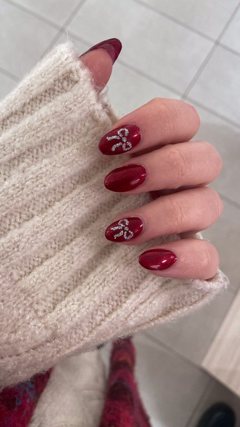 a picture of my hand, i did my nails in an almond shape with shiny red polish, on my index and ring finger i painted sparkly little bows Bauble Nail Art, Christmas Nails Bow Design, Christmas Nails Biab, Bow Christmas Nails, Christmas Gel Nails Short, Christmas Bow Nails, Xmas Nail, Uñas Ideas, Bow Nails