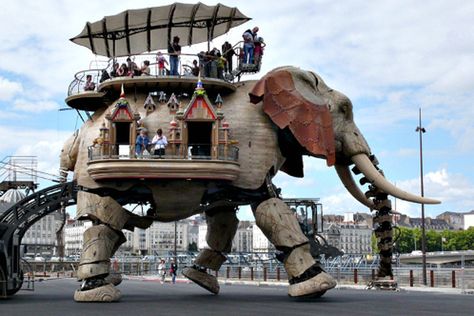 The Great Elephant is 12 meters high, 45 tons, can carry 49 people on its back for a promenade along the Loire River. It's powered by the motor from a city bus. It also trumpets, wags its tail, blinks its eyes, sprays people with water from its trunk, and has been known to pee on the sidewalk. It is of the Machines of the Isle of Nantes, an oasis of whimsical creatures inspired by Nantes native Jules Verne, housed in what was until recently a decommissioned shipyard and industrial wasteland. Loire River, Steampunk Animals, Nantes France, City Bus, Jules Verne, Daily Pictures, Trumpets, Exploring The World, Children's Literature