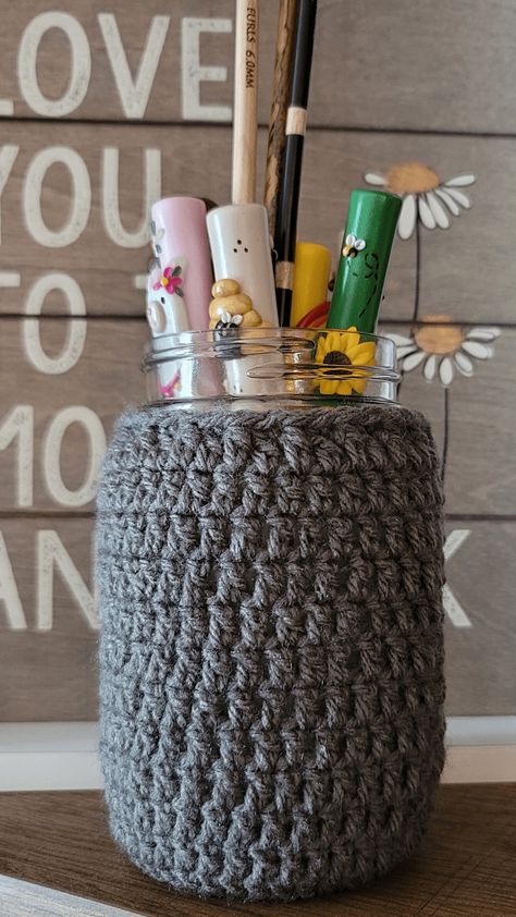 I designed this Mason Jar Cover Crochet Pattern to use to cover an old canning jar I had at home. I needed somewhere to put my Furls Tunisian Crochet Hooks but you can use them for so many purposes! These cozies make great, versatile gifts. This pattern is free and available in multiple sizes. #yarnspirations #caron #littlecrafties #pedrosplaques #crochetpattern #masonjar #furlscrochet #furlsinf721 Crochet Jar Covers, Mason Jar Cozy, Quick Crochet Projects, Tunisian Crochet Hook, Crochet Ball, Cozy Crochet Patterns, Crochet Cozy, Small Mason Jars, Cozy Crochet