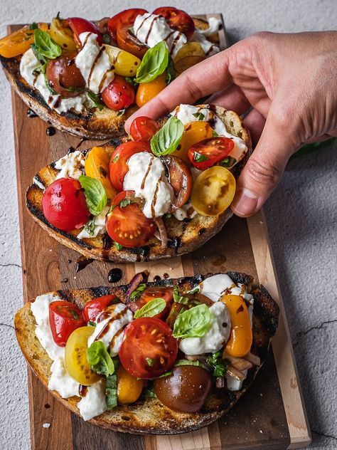 Bruschetta topped with cherry tomatoes, cheese and herbs. Summer Burrata Board, Bistro Lunch Ideas, Brushetta Appetizers Burrata, Burrata Presentation, Tomatoe Mozz Basil, Simple Bruschetta Recipe, Authentic Bruschetta Recipe, Tomatoes Recipes Fresh, Garden Party Sandwiches