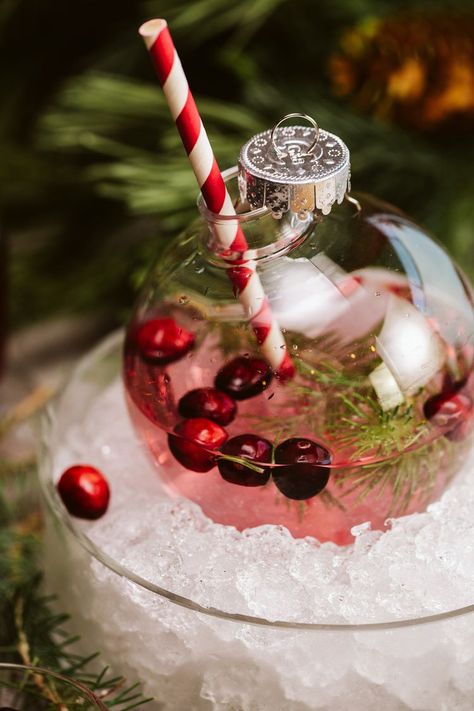 10 Festive Cocktails to Make This Holiday Season Christmas Drinks Decorations, Christmas Drink In Ornament, Christmas Bulb Drink Ideas, Holiday Drinks In Ornaments, Christmas Cocktail Presentation, Christmas Ball Ornament Drinks, Christmas Wedding Drinks, Christmas Drinks In Ornaments, Christmas Cocktails In Ornaments