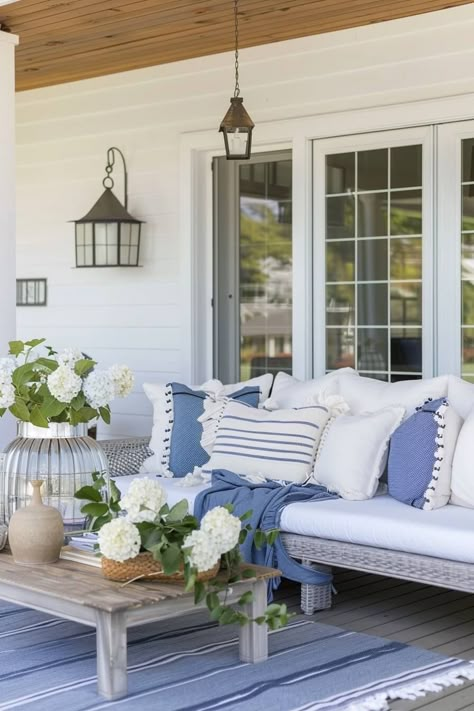 Discover 12 creative coastal front porch ideas to transform your outdoor space into a serene summer retreat, featuring porch swings, hammocks, nautical touches, and more! Add a coastal vibe to your front porch even if you're home isn't directly on the coast. Transform Your Porch: 12 Coastal Design Tips for a Summer Oasis -Casually Coastal. Blue And White Outdoor Patio, Serena And Lily Outdoor Patio, Coastal Balcony Ideas, Nantucket Porch, Coastal Front Porch Ideas, Porch Renovation Ideas, Coastal Front Porch, Coastal Outdoor Living, Beach House Deck