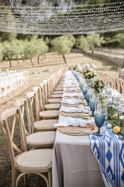 Simple natural blue and citrus yellow wedding table decor and string light set up for finca wedding reception dinner in Mallorca | photo @mariahibbsphotography Mallorca Wedding Table, Mediterranean Table Setting Wedding, Greece Table Decor, Blue And Yellow Wedding Table Decor, Lemon Wedding Table Decor, Wedding Decor Light Blue, Yellow And Blue Table Decor, Mediterranean Blue Wedding, Yellow Wedding Table Decorations