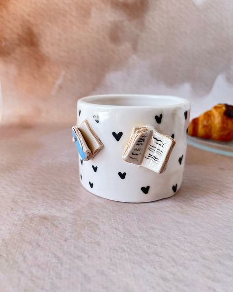 Start your mornings with the perfect blend of coffee and books! 📚☕ Our ceramic mug with book details and a croissant handle is a must-have for book lovers. #etsy #booklover #bookish #ceramicgift #BookLovers #Handmade #CoffeeTime #UniqueDesign Pottery Books Ceramic Art, Pottery Ideas Mug, Ceramic Mugs Designs Creative, Bookish Gift Ideas, Cup Designs Ideas, Handmade Mugs Pottery, Book Pottery, Ceramic Gift Ideas, Pottery Gift Ideas