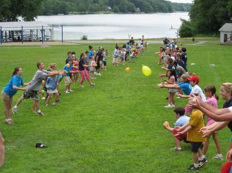 Summer Camp Enjoying A Game Of Water Balloon Toss Water Balloon Toss Game, Waterballoon Toss, Adult Field Day Activities, Water Balloon Toss, Camping Games For Adults, Water Balloon Games, Fun Easter Games, Camp Games, Summer Camp Games