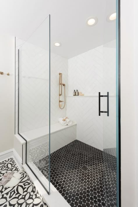 This luxury walk-in shower pairs white tile walls with black marble floor tiles. At HGTV.com, check out the chic look. Shower With Black Tile, Black Tile Floor, Black And White Bathroom Floor, Master Shower Tile, White Shower Tile, White Marble Shower, Black Marble Floor, Marble Floor Tiles, White Tile Shower