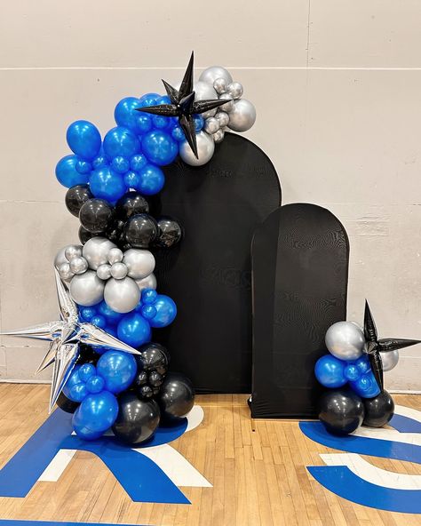 🔷🔹 U Prep Homecoming Games 🔹🔷 The Hunger Games Homecoming theme came together flawlessly. 🖲️ Blue flame gauntlet Creative Columns. Custom lit balloon garland made for their hoco backdrop with silver starbursts. Custom garland with Mylar starburst and spandex cover on backdrop rental. Color palette: black, silver, and metallic blue Blue Silver Black Birthday Theme, Black And Blue Balloon Garland, Backdrop Rental, Homecoming Themes, Homecoming Games, Blue Flame, Black Balloons, Blue Balloons, Blue Flames