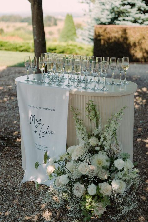 What a dreamy setup! 1 metre linen welcome sign used as the most gorgeous drinks station at @campdavidfarm 🫶🏼 _____________________ info@ateliercreativeau.com ateliercreativeau.com * * * #customsignage #weddinginvites #weddinginvitationideas #weddingflowers #weddingdesign #weddingstylist #weddingflowersau #customdesign #luxewedding #bespokeflorals #weddingdaydetails #weddingsignage #weddingstationery #eventflorals #floraldesigner #weddingcreative #invitations #weddingstationer #floraldesign... Champagne Welcome Table Wedding, Ceremony Welcome Drinks, Champagne Sign Wedding, Wedding Welcome Champagne, Wedding Drink Table Ideas, Welcome Champagne Wedding, Water Station Wedding, Welcome Drink Ideas, Wedding Bar Decorations