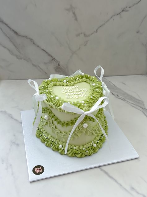 Sage green vintage heart cake with white bows and pearls Green Heart Birthday Cake, Green Cakes Ideas, Smiski Cake, Light Green Birthday Cake, Green Sweet 16 Cake, Green Aesthetic Cake, Sage Green Cake Ideas, Olive Green Cake, Green Cake Aesthetic