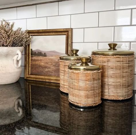 Organize your space in pure style with our Rattan Wrapped Storage Canisters, Set of 4. This canister comes in a set of four sizes, each with rattan-wrapped detailing, a brass finish, and lids for easy storing. These gorgeous canisters are great for storing and displaying and will look great in any farmhouse home! Cannister Ideas Kitchen, Pantry Canisters, Shabby Chic Antiques, Model Accessories, Backyard House, Storage Canisters, Vintage Baskets, Wood Creations, Antique Farmhouse