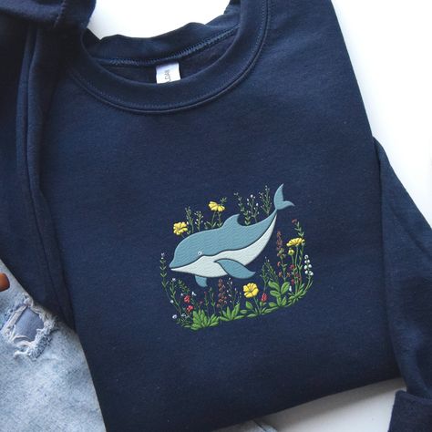 𝑬𝒎𝒃𝒓𝒐𝒊𝒅𝒆𝒓𝒆𝒅 𝑫𝒐𝒍𝒑𝒉𝒊𝒏 𝒔𝒘𝒆𝒂𝒕𝒔𝒉𝒊𝒓𝒕 🐬 🐬 This adorable and whimsical dolphin Sweatshirt is a great addition to your all season wardrobe! It's prefect for taking a walk, running errands, chilling at home, or hanging out with friends! Our crewnecks are made from the highest quality fabric for an incredibly soft and comfortable fit. You can find the sweater in my Etsy Shop 🤍 👉🏻link in Bio #embroiderydesigns #embroideredart #embroidery #sweatshirtforwomen #embroidered #embroiderywork #EmbroideryLove ... Whale Sweatshirt, Ocean Sweatshirt, Embroidered Whale, Sunset At The Beach, Aesthetic Sweatshirt, Animal Sweater, Floral Aesthetic, Cute Whales, Animal Sweatshirt