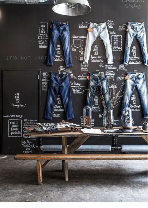 The Good Genes store in Amsterdam utilized signage by way of chalkboard drawings. Their branding is to emphasize slow fashion while being home grown and rustic. This chalkboard display breaks down the components of the denim. This with the "workshop" display in front of it makes the consumer understand that this is not a fashion fashion brand, but one that puts thought and love into the products they create. Denim Display, Display Visual Merchandising, Paulina Arcklin, Vitrine Design, Teen Clothing Stores, Clothing Store Displays, Diy Tv Stand, Jeans Store, Clothing Displays