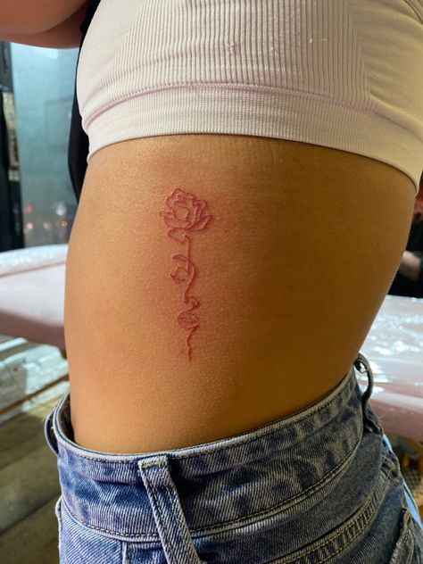 Hip Tattoos Women Red Ink, Tattoo Ideas Female Red Ink Small, Red Tattoo On Side Ribs, Red Tattoo On Hip, Red Ink Side Tattoo, Red Cute Tattoos, Red Rib Cage Tattoos, Red Tattoo On Light Skin, Red Dainty Tattoos For Women