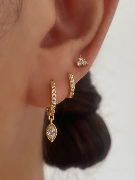 Indulge in timeless sophistication with our exquisite gold dangle earrings set, meticulously crafted from 925 sterling silver with 18k gold plated. This set features three stunning pairs, each designed to enhance your style effortlessly. Whether you choose to wear a single pair or all three, they will be absolutely gorgeous. A. Dangle Earring• Material: 18k gold on 925 Sterling Silver, AAAAA Cubic Zirconia• Size: Length : 15mm, Hoop inner diameter: 9mm• Hypoallergenic, lead and nickel-free• Sold Three Ear Piercings, Gold Earring Set, Minimalist Ear Piercings, Pretty Ear Piercings, Cute Ear Piercings, Gold Dangle Earrings, Silver Jewelry Earrings, Jewelry Fashion Trends, Gold Earrings Designs