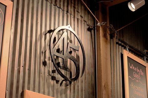 Steel Logo Against Corrugated Metal by Forty-Five North, via Flickr Wooden Farm Signs, Ranch Office, Corrugated Metal Wall, Church Lobby, Steel Logo, Cattle Brands, Warehouse Design, Living Area Design, Wall Logo