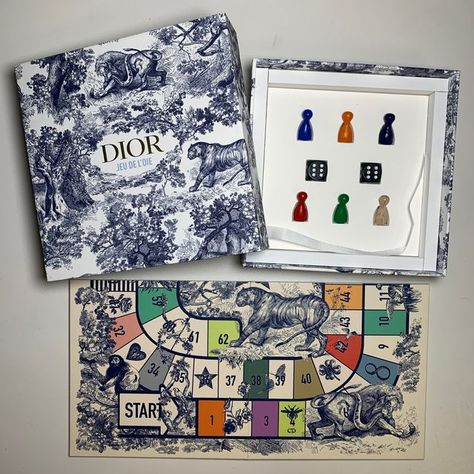 Thomas J. Watson Library on Instagram: "This beautiful box was sent out by Dior as the invitation to their Spring/Summer 2022 show, presented in Paris. Once unpacked the box contains a colorful gameboard, game pieces, and the rules of play card for the game Jeu de l’Oie. More unique items that are sent out as fashion show invitations can be found in @costumeinstitutelibrary!  #MetLibrary #MetCostumeInstitute #CostumeInstituteLibrary #Boardgame #Boardgames #BoardGameDesign #FrenchGames #Dior #FashionShow #FashionShowInvite #FashionShowInvites #SpringSummer22 #HauteCouture #FrenchFashion #Boxes #Toile #ToileArt #ToileAddict #Oie" Playing Card Packaging, Unique Board Games, Boardgame Design, Fashion Invitation, Fashion Show Invitation, Board Game Box, Play Card, Brand Launch, Board Game Design