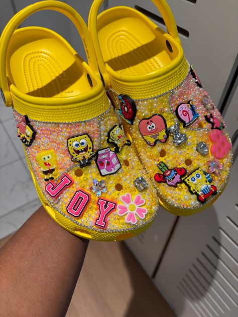 Hello, welcome to my shop   All custom designed shoes are made to order. Please allow 7-10 days to complete your order and 3-5 days for shipping.   When placing your order try to be as detailed as possible if you are not sure I can give suggestions or freestyle with charms, rhinestone, pearls and/or patches to match your chosen theme. No two crocs will be identical or match the listing picture exactly.   All sales are final on custom work. Some croc colors may not be available to me in the size Yellow Bedazzled Crocs, Junk Crocs, Spongebob Crocs, Croc Charms Ideas, Croc Colors, Croc Inspiration, Baddie Crocs, Crocs Decorations, Decorated Crocs