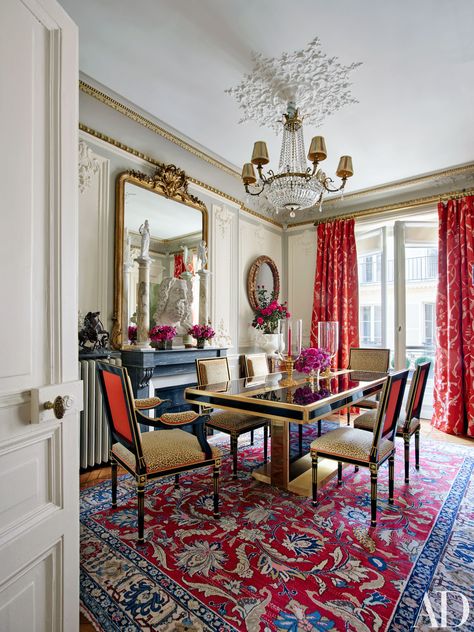 Rich colors and patterns mix in the dining room of Timothy Corrigan's magnificent Paris pied-à-terre. | archdigest.com Paris Apartment Decor, Timothy Corrigan, San Myshuno, Red Dining Room, Classic Dining Room, Dining Room Interiors, Interior Design Photos, Red Curtains, Paris Apartments