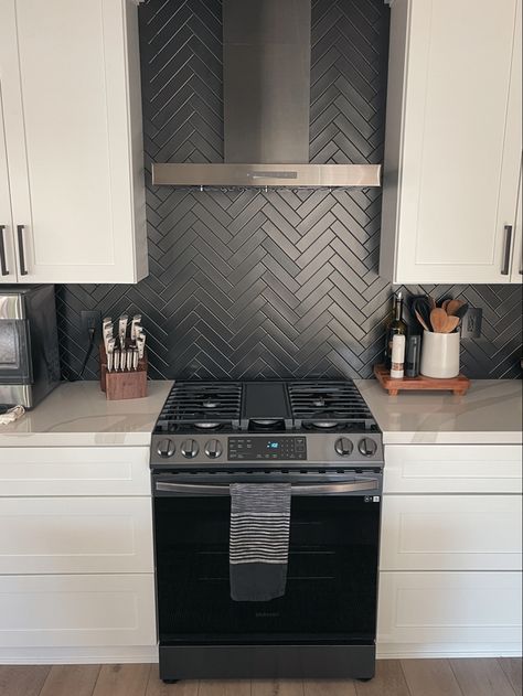 Matte black herringbone kitchen backsplash, white shaker cabinets. White Cupboards Black Backsplash, Black Stacked Backsplash, Black Backsplash Wood Countertop, Black Matte Backsplash Kitchen, Black Backsplash Black Grout, Matte Black Herringbone Backsplash, White Subway Tile Kitchen Backsplash With Black Accent, Black Tile Backsplash Kitchen White Cabinets, Black Matte Backsplash