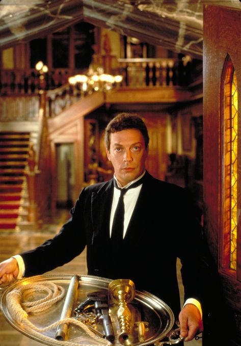 "Clue" promo still, 1985.  Tim Curry as Wadsworth.  Jonathan Lynn was brought in as director and wanted British actor Leonard Rossiter to play the butler.  However, Rossiter died before the film began and Lynn's second choice was a British comic who was rejected by Paramount because he was unknown in the United States.  His name was Rowan Atkinson - Mr. Bean himself!  Curry was the third choice - remarkable. Clue 1985, Clue Costume, Classic Halloween Movies, Clue Movie, Clue Party, Best Halloween Movies, Tim Curry, Mystery Dinner, The Rocky Horror Picture Show