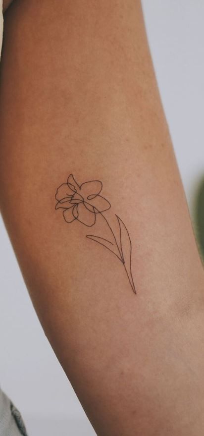 Tattooed With Meaning, Patchwork, Ankle Daffodil Tattoo, Small Line Art Flower Tattoos, Gerber Daisy Tattoo Designs, Linework Daffodil Tattoo, Daffodil Behind Ear Tattoo, Matching Daffodil Tattoos, Simplistic Daffodil Tattoo