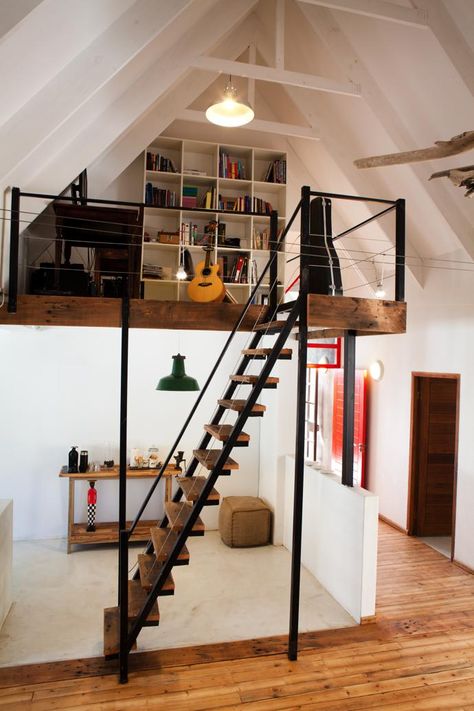 The mezzanine level makes the perfect study nook. Mezzanine Study Area, Loft Ladder Design, Mezzanine Library Bookshelves, Stairs To Mezzanine, Bungalow Mezzanine, Narrow Loft Ideas, Small Mezzanine Office, Mezzanine Stairs Ideas, Mezannine Loft Interior Design