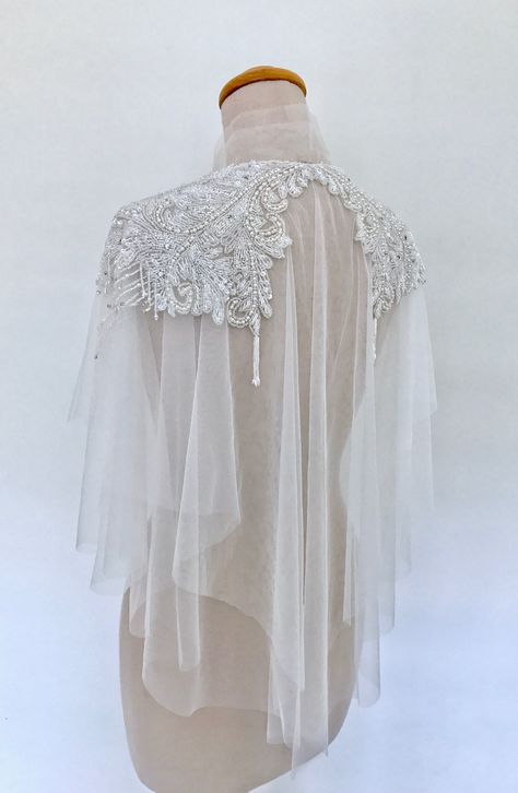 Crafted from airy tulle, this stunning cape is intricately embellished with white pearls, bugle and seed beads. Falling just beyond the elbows it brings an elevated shimmer and luxurious texture to your look. #capelet #wedding Couture, Haute Couture, Wedding Dress Capelet, Wedding Capelet, Lace Capelet, Bridal Capelet, Off White Wedding, Wedding Dress Backs, Cape Wedding