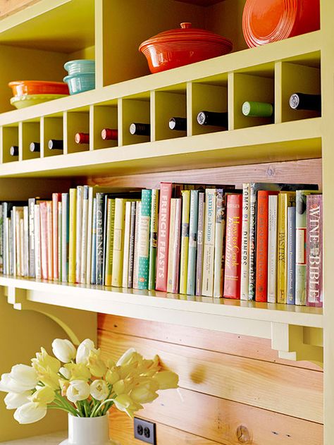 Oh, what to do with all those cookbooks? This bright bookshelf/storage wall solves that problem with style. Simple cubbies above the books store single bottles of wine, and colorful baking and serving dishes are displayed on the shelves above. Cookbook Display, Kitchen Bookshelf, Cookbook Storage, Decor Above Cabinets, Cookbook Shelf, Kitchen Furniture Storage, Inset Cabinets, Above Kitchen Cabinets, Above Cabinets