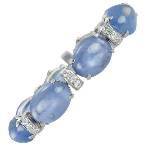 1930s Seaman Schepps Sapphire Cabochon Diamond Platinum Bracelet. A stunning Seamen Schepps Art Deco platinum line bracelet from circa 1930s. This striking bracelet consists of 24 Old European Cut diamonds (approximately 3.60 carats in total diamond weight) set on roundel style links that alternate with sapphires. The beautiful blue hues of the natural, no-heat sapphire cabochons slightly graduate in size to the largest center cabochon sapphire. The 8 sapphires total approximately 100 carats. Seaman Schepps, Platinum Bracelet, Sapphire Cabochon, Vintage Designer Jewelry, Antique Bracelets, Swarovski Bracelet, Weight Set, Platinum Jewelry, Art Nouveau Jewelry