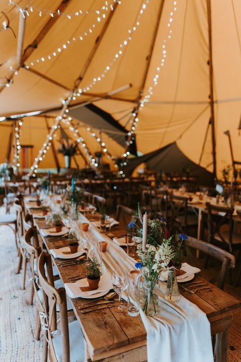 Tipi Wedding Decor Rustic Tables Jonny Gouldstone Photography #tipiwedding #weddingideas Tipi Wedding Photography, Tipi Decoration Wedding, Boho Festival Wedding Decor, Festival Wedding Table Decor, Rustic Decoration Wedding, Boho Tipi Wedding, Festival Wedding Table Decorations, Rustic Wedding Long Table Decor, Festival Wedding Ideas Decor