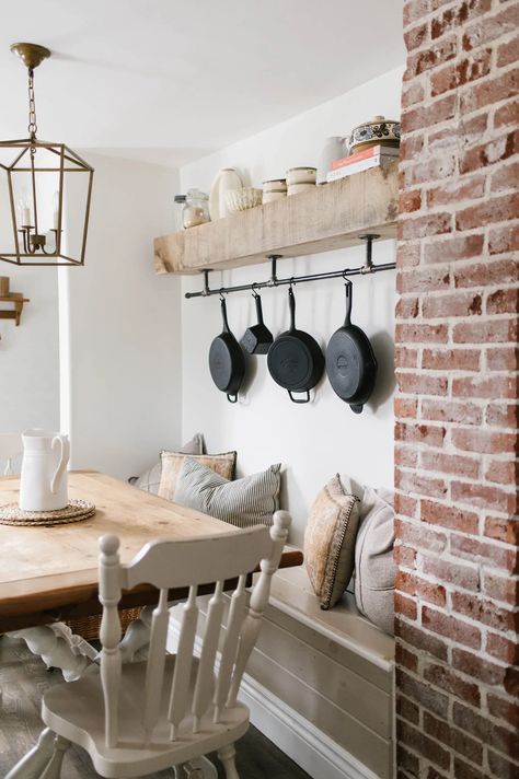 Cast iron skillets hanging on a black steel pipe shelf. Cast Iron Skillet Storage Wall, Cast Iron Pot Storage, Open Wall In Kitchen Ideas, Ways To Hang Cast Iron Skillets, Cast Iron Hanging On Wall, Cast Iron Storage Ideas Display, Cast Iron Wall Storage, Cast Iron Hanging Ideas, Hanging Cast Iron Pans The Wall