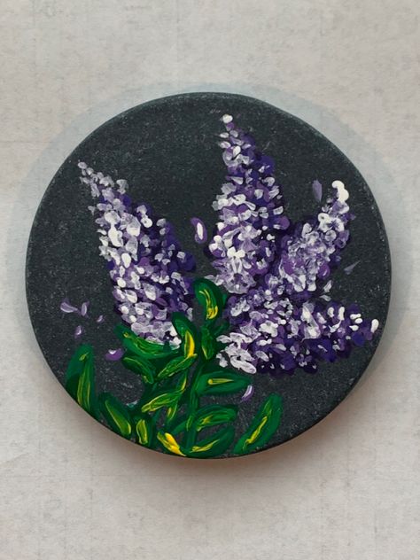 Purple Lilac flowers painted on a black round disc shaped stone. Lilac Rock Painting, Lilac Paint, Purple Painting, Rock Painting Designs, Painting Designs, Hand Painted Rocks, Rock Collection, Stone Art, Rock Painting