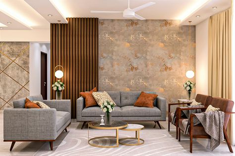 The grey textured fabric used in the wooden-framed sofa set with brown cushions adds a contrast to the room. Two brown accent chairs on the side complement the pale grey rug. The textured wall with a tint of gold and side wooden panelling enhances the look. A round nesting table with black and white marble table top and gold framework matches well with the overall interior. Living Area Wallpaper, Living Room Indian, Wallpaper House Design, Wooden Panelling, Drawing Room Interior Design, Drawing Room Interior, Living Room Wall Color, Latest Living Room Designs, Gold Living Room