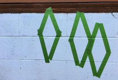 A cinder block wall does not have to be plain or an eyesore. Just grab some paint and a stencil and turn it into a feature! Our deck was built on a cinder block foundation, which is right by the swimming pool. I was tired of it looking unfinished, so I decided to paint it white, then added a pop of color with a fun design. See how I transformed this wall in one afternoon! I had painted the wall several years ago, but it was in need of a fresh coat of paint. After pressure washing the… Backyard Wall Murals Cinder Blocks, Mural On Cinder Block Wall, Paint Cinder Block Wall, Cinder Block Foundation, Block Foundation, Backyard Wall, Accent Wall Entryway, Hallway Gallery Wall, Painted Brick Walls