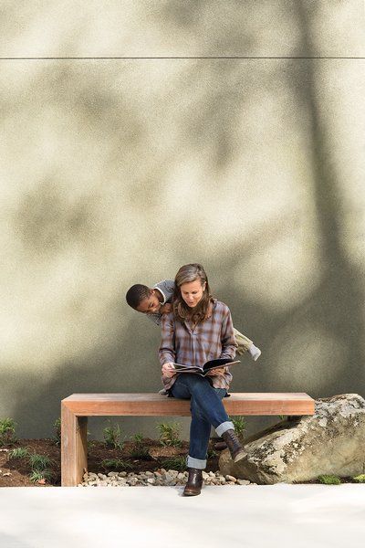 Birdsall and Atticus are seated on an ipe bench designed by Anna Boeschenstein; the stucco exterior cladding was matched to Cast Iron 6202 paint by Sherwin-Williams. Ipe Bench, Outdoor Bench Seating, Modern Courtyard, Modern Outdoor Spaces, Ipe Wood, Stucco Exterior, Porch Deck, Stucco Walls, Bench Designs